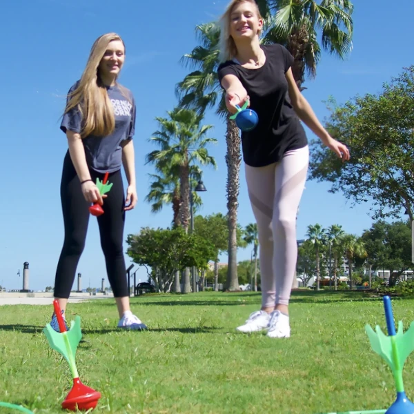 Two girls playing Funsparks Lawn Darts in a park